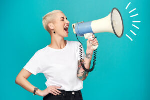 This image shows a woman yelling into a megaphone to provide emphasis on the proper way to create marketing to women.