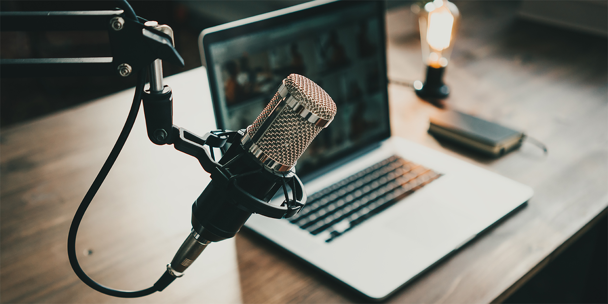 Studio microphone set up in front of a laptop for podcast recording