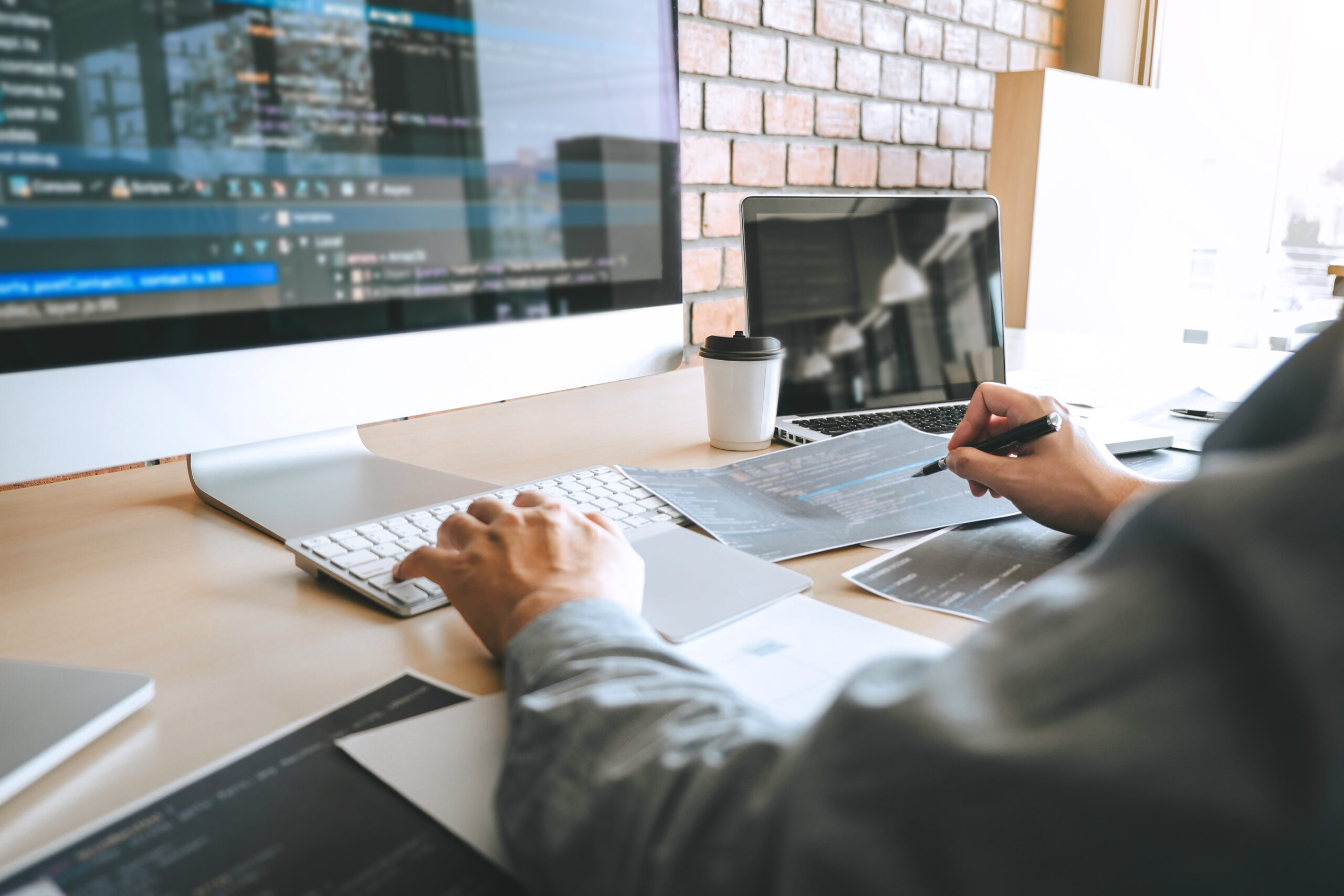 Developer working at a desk with multiple monitors