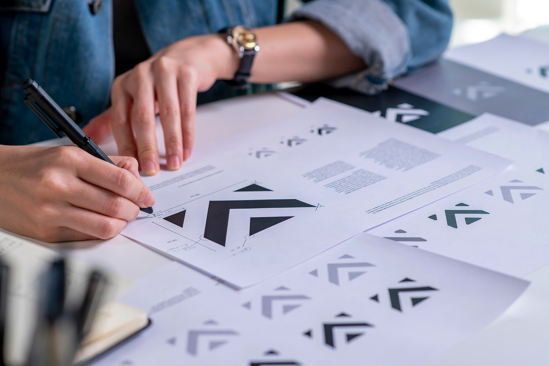 Designer sketching brand logo concepts on paper during brand development