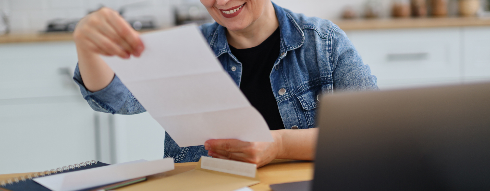 Woman opening a direct mail letter at her desk