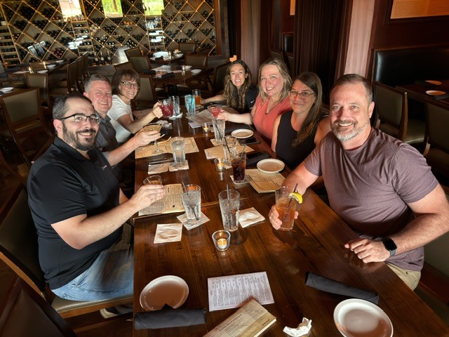 Ironistic team members gathered around a table for a team dinner - ironistic